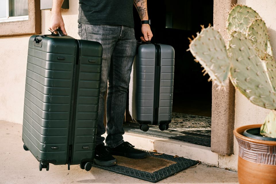 hombre-con-dos-maletas-en-puerta-de-una-casa