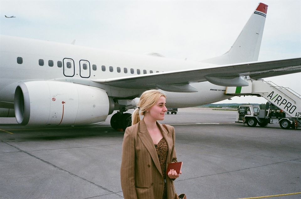mujer-con-un-avión-de-fondo-en-pista-aterrizaje