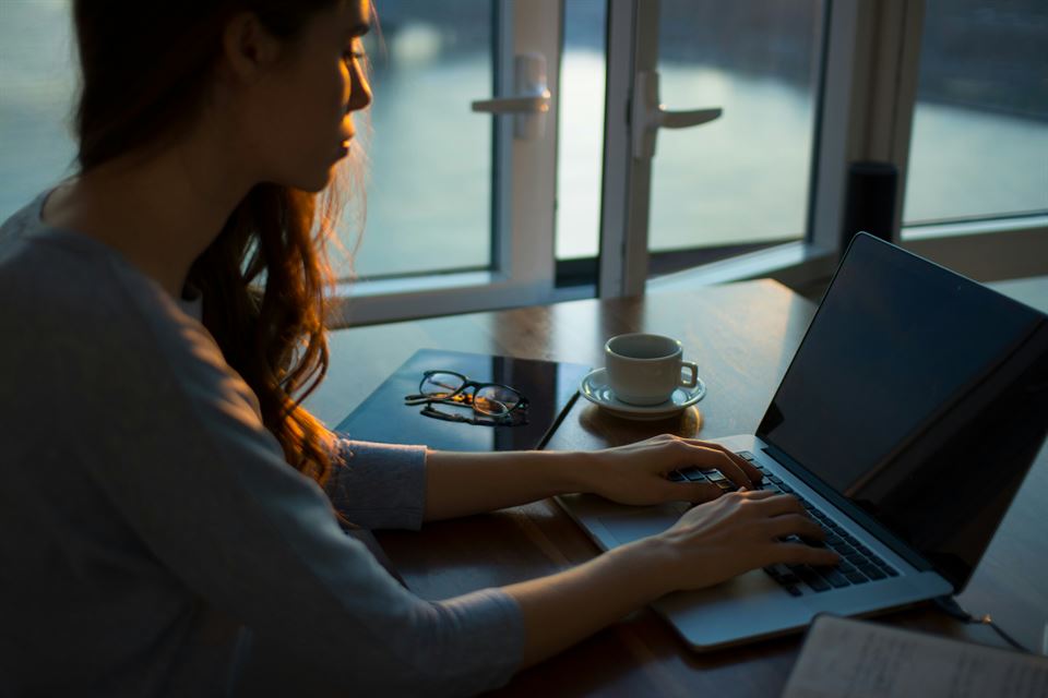 mujer-escribe-sobre-portatil